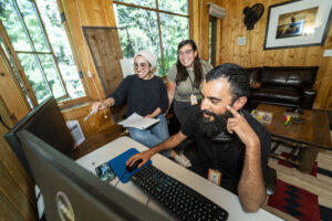 Fahd, Stephanie, and June gather around an editing screen