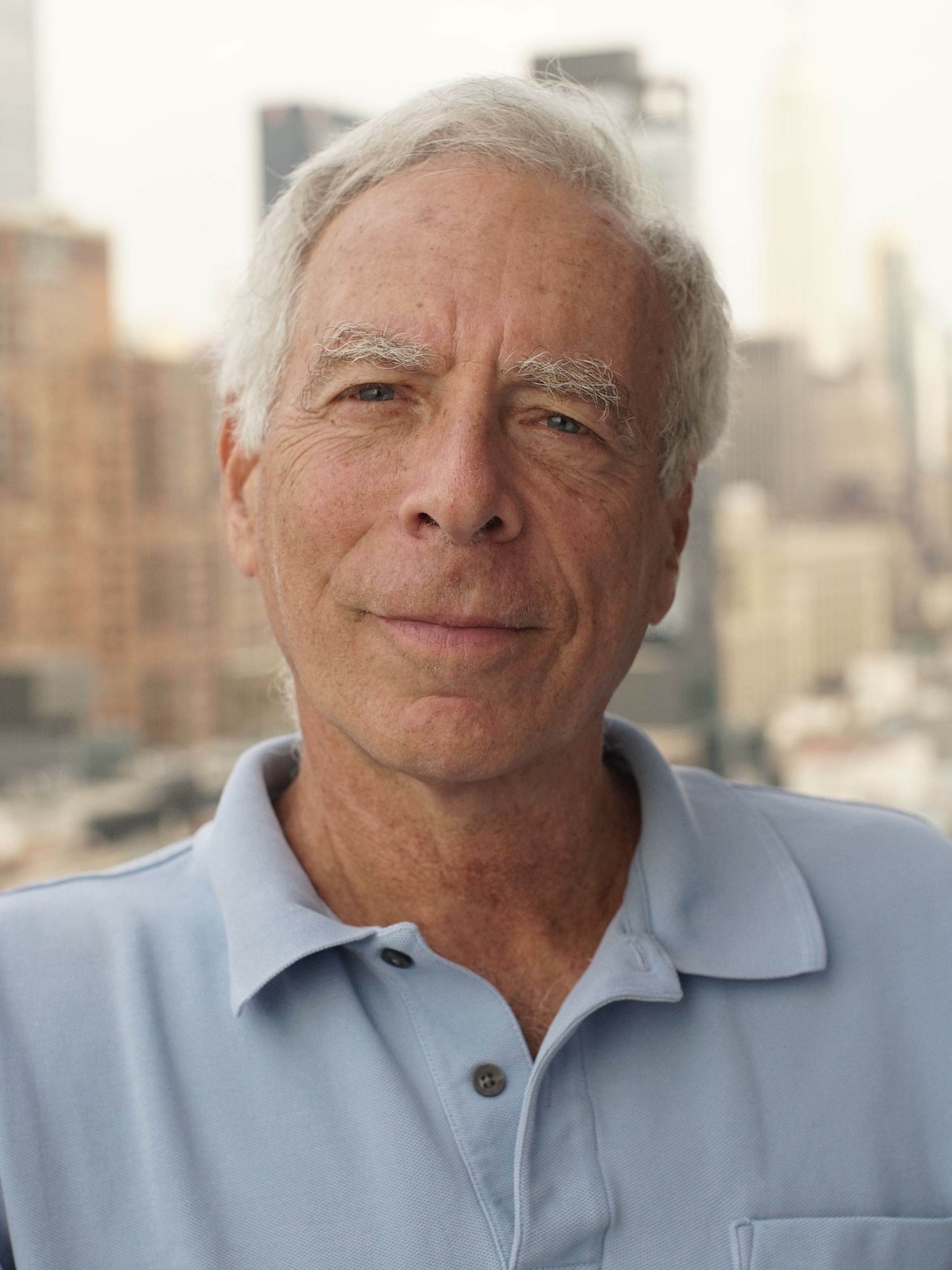 older white man in a blue polo looking at the camera